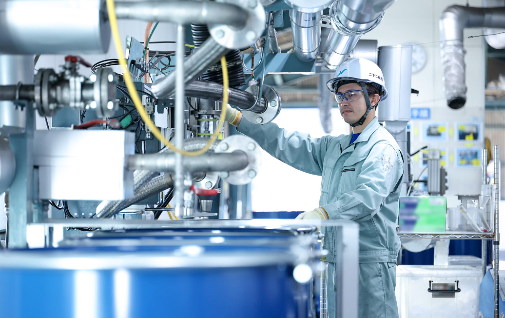 ドラム缶への充填を行うA.Hさん